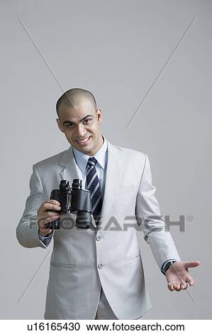 Portrait of a businessman holding binoculars and smiling View Large Photo Image Stock Image - Portrait of a businessman holding binoculars and smiling. Fotosearch