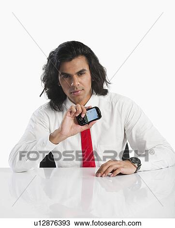 Portrait of a businessman showing a mobile phone View Large Photo Image Stock Image - Portrait of a businessman showing a mobile phone. Fotosearch