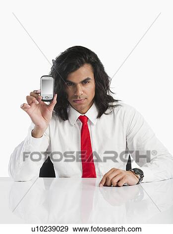 Portrait of a businessman showing a mobile phone View Large Photo Image Stock Photo - Portrait of a businessman showing a mobile phone. Fotosearch