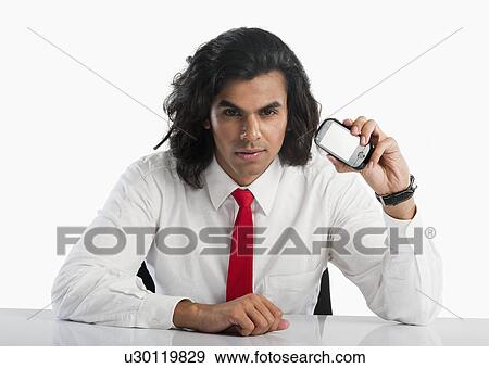 Portrait of a businessman showing a mobile phone View Large Photo Image Stock Photo - Portrait of a businessman showing a mobile phone. Fotosearch