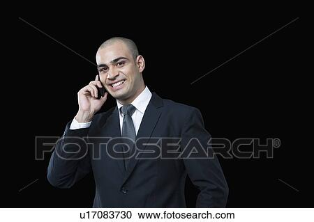 Portrait of a businessman talking on a mobile phone View Large Photo Image Stock Image - Portrait of a businessman talking on a mobile phone. Fotosearch