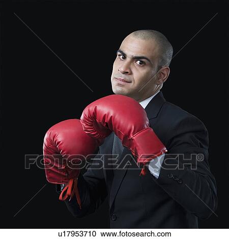 Portrait of a businessman wearing a boxing glove View Large Photo Image Stock Image - Portrait of a businessman wearing a boxing glove. Fotosearch