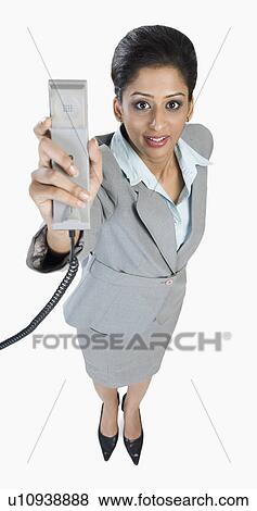 Portrait of a businesswoman holding a telephone receiver View Large Photo Image Stock Photo - Portrait of a businesswoman holding a telephone receiver. Fotosearch