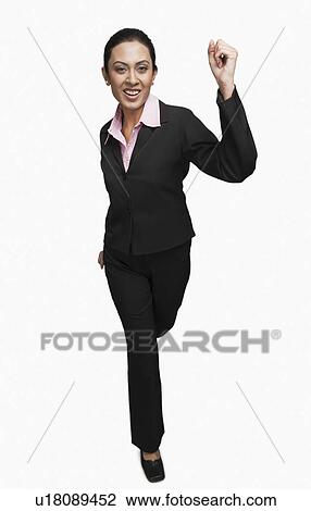 Stock Image - Portrait of a businesswoman running and smiling. Fotosearch