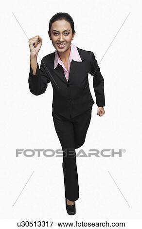 Stock Photo - Portrait of a businesswoman running and smiling. Fotosearch