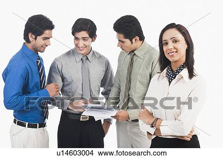 Picture - Portrait of a businesswoman with her colleagues discussing in the background. Fotosearch