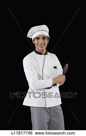 Stock Photograph - Portrait of a chef holding a spatula. Fotosearch