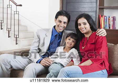 Stock Photo - Portrait of a couple smiling with their daughter. Fotosearch