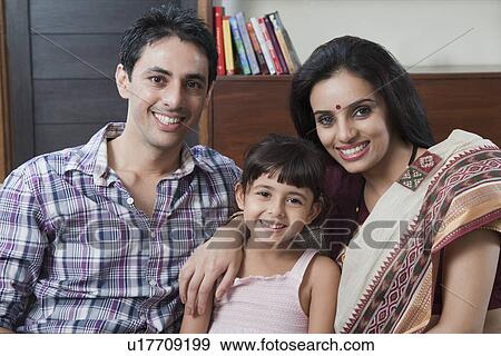 Stock Photo - Portrait of a couple smiling with their daughter. Fotosearch