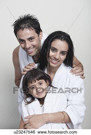 Stock Photograph - Portrait of a couple smiling with their daughter. Fotosearch