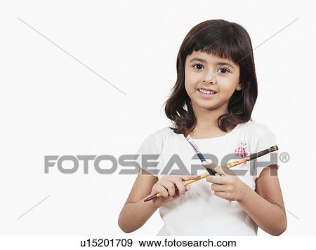 Stock Photo - Portrait of a girl holding paintbrushes. Fotosearch