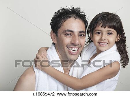 Stock Image - Portrait of a girl hugging her father. Fotosearch