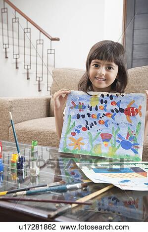 Stock Image - Portrait of a girl showing a painting. Fotosearch