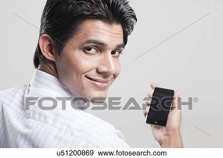 Portrait of a man holding a mobile phone View Large Photo Image Stock Photo - Portrait of a man holding a mobile phone. Fotosearch