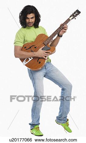 Stock Photograph - Portrait of a man playing a guitar. Fotosearch