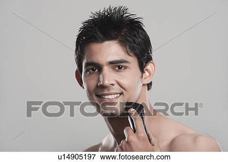 Portrait of a man shaving with electric razor View Large Photo Image Stock Photo - Portrait of a man shaving with electric razor. Fotosearch