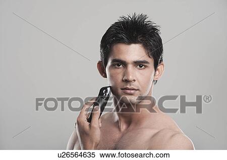 Portrait of a man shaving with electric razor View Large Photo Image Stock Photography - Portrait of a man shaving with electric razor. Fotosearch