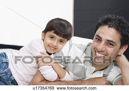 Portrait of a man smiling with his daughter View Large Photo Image Stock Photo - Portrait of a man smiling with his daughter. Fotosearch