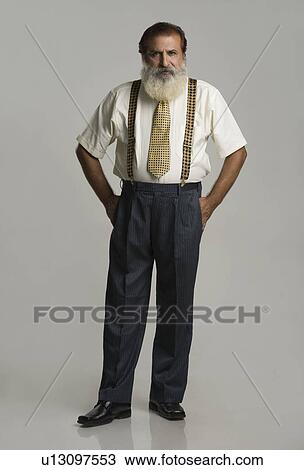 Portrait of a man standing with his hands in his pockets View Large Photo Image Stock Image - Portrait of a man standing with his hands in his pockets. Fotosearch