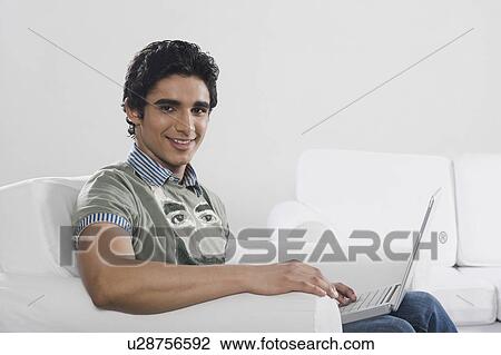 Stock Image - Portrait of a man using a laptop. Fotosearch