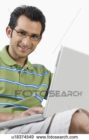 Portrait of a man using a laptop View Large Photo Image Stock Photo - Portrait of a man using a laptop. Fotosearch