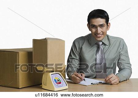 Stock Photograph - Portrait of a man weighing cardboard boxes and recording data. Fotosearch