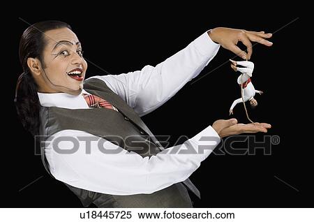 Stock Photography - Portrait of a mime holding a rope with two acrobat performing on it. Fotosearch