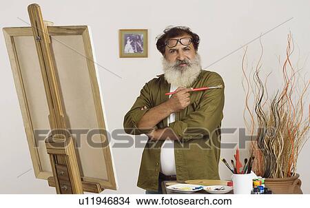 Portrait of a painter holding a paintbrush View Large Photo Image Picture - Portrait of a painter holding a paintbrush. Fotosearch