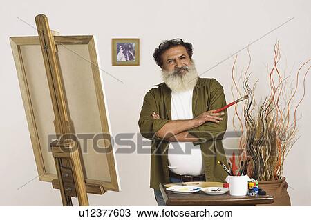 Portrait of a painter standing with his arms crossed View Large Photo Image Stock Image - Portrait of a painter standing with his arms crossed. Fotosearch