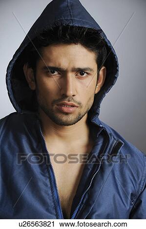 Stock Image - Portrait of a stylish young man wearing hooded shirt. Fotosearch