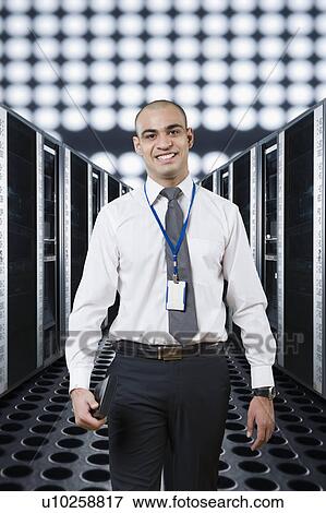 Portrait of a technician smiling in a server room View Large Photo Image Stock Photo - Portrait of a technician smiling in a server room. Fotosearch