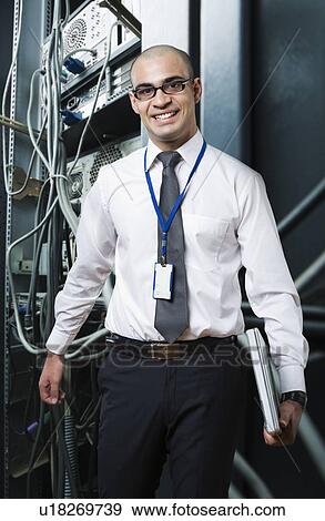 Portrait of a technician smiling in a server room View Large Photo Image Stock Photo - Portrait of a technician smiling in a server room. Fotosearch