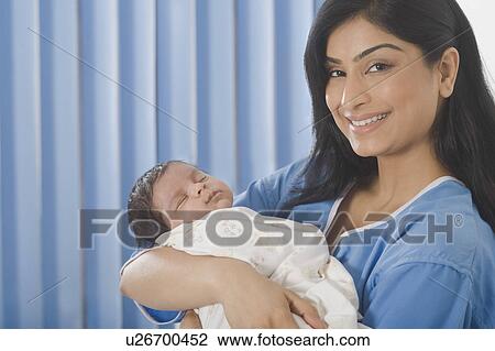 Portrait of a woman carrying her baby and smiling View Large Photo Image Stock Image - Portrait of a woman carrying her baby and smiling. Fotosearch