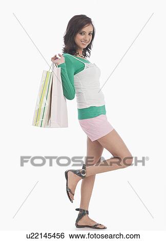 Stock Photograph - Portrait of a woman carrying shopping bags. Fotosearch