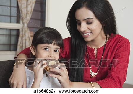 Portrait of a woman feeding toast to her daughter View Large Photo Image Stock Photo - Portrait of a woman feeding toast to her daughter. Fotosearch