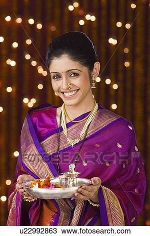 Portrait of a woman holding a pooja thali View Large Photo Image Stock Image - Portrait of a woman holding a pooja thali. Fotosearch