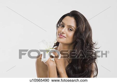 Stock Image - Portrait of a woman holding a Tiger Lily flower. Fotosearch