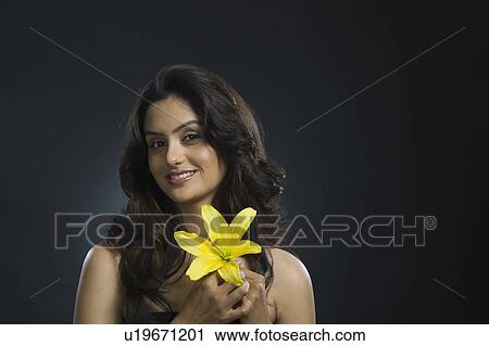 Stock Image - Portrait of a woman holding a Tiger Lily flower. Fotosearch