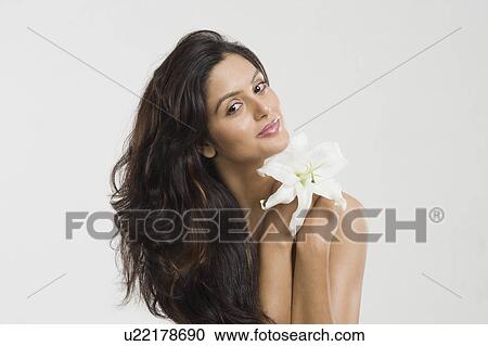 Stock Image - Portrait of a woman holding a Tiger Lily flower. Fotosearch
