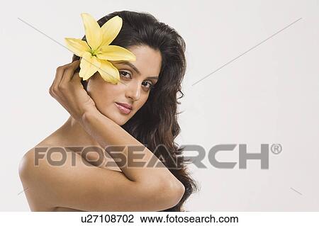 Stock Image - Portrait of a woman holding a Tiger Lily flower. Fotosearch