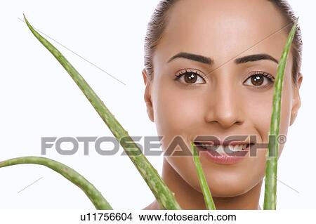 Picture - Portrait of a woman holding an Aloe Vera plant. Fotosearch
