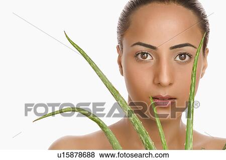 Stock Photo - Portrait of a woman holding an Aloe Vera plant. Fotosearch