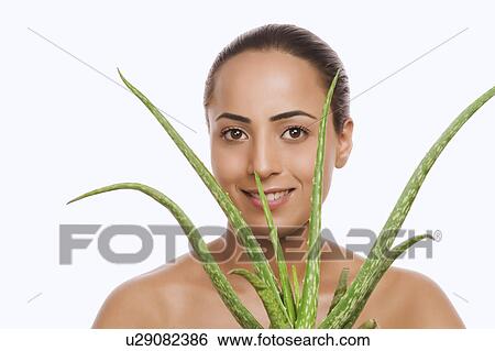 Portrait of a woman holding an Aloe Vera plant View Large Photo Image Stock Photograph - Portrait of a woman holding an Aloe Vera plant. Fotosearch