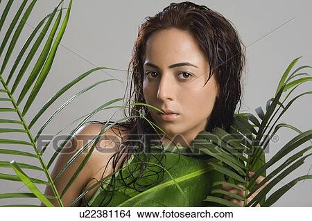 Picture - Portrait of a woman holding leaves. Fotosearch