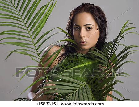 Stock Image - Portrait of a woman holding leaves. Fotosearch