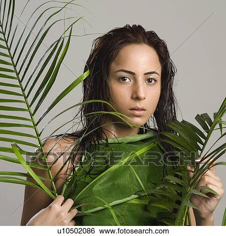 Portrait of a woman holding leaves View Large Photo Image Stock Photograph - Portrait of a woman holding leaves. Fotosearch