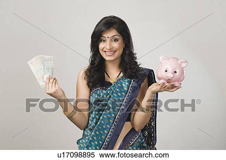 Portrait of a woman holding money and a piggybank View Large Photo Image Stock Photography - Portrait of a woman holding money and a piggybank. Fotosearch