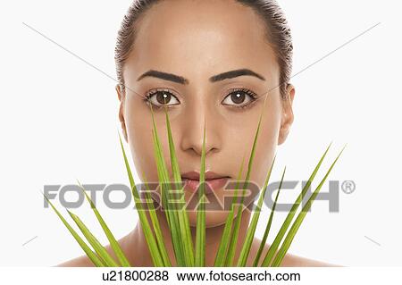 Stock Photo - Portrait of a woman holding palm leaves. Fotosearch