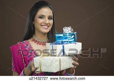 Stock Photo - Portrait of a woman holding stack of gifts. Fotosearch