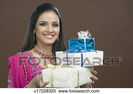 Portrait of a woman holding stack of gifts View Large Photo Image Stock Photography - Portrait of a woman holding stack of gifts. Fotosearch